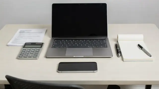 Büro-Setup mit Laptop und Unterlagen zur Krankenversicherung für Selbstständige