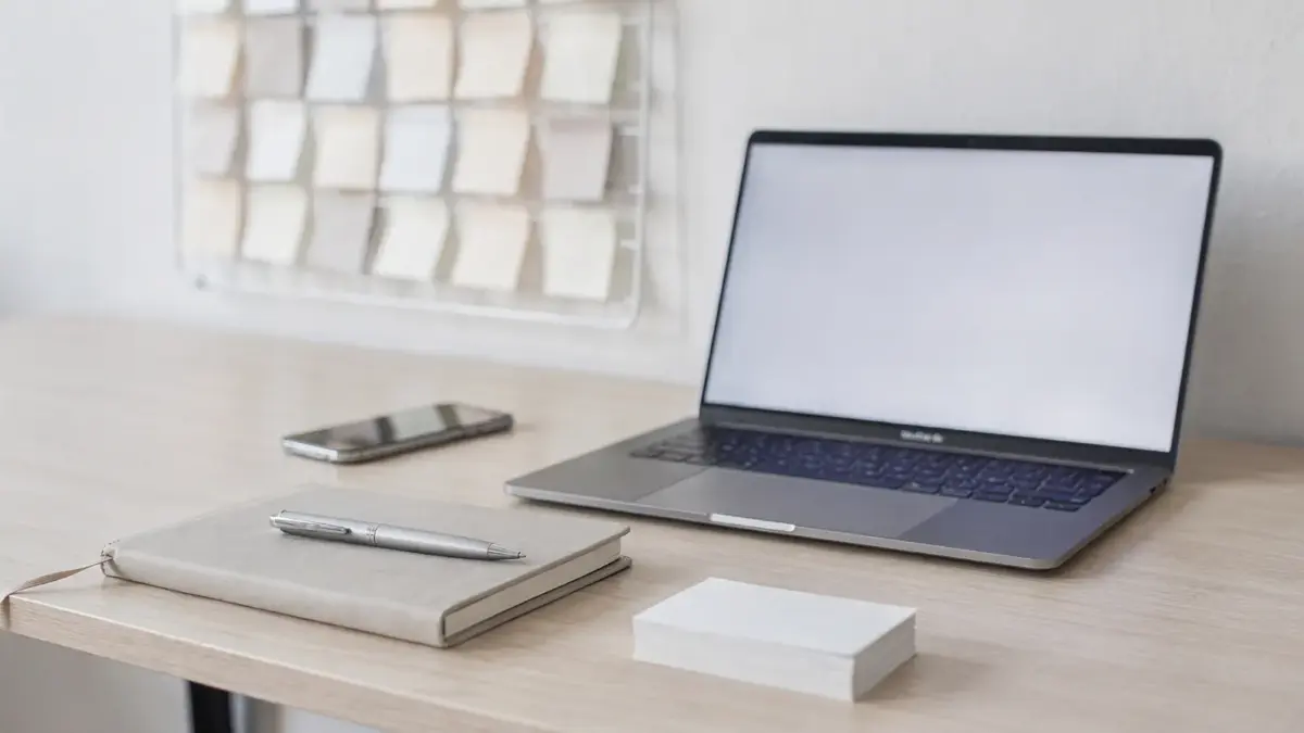 Arbeitsplatz eines Selbstständigen mit Laptop, Notizbuch und Planungstafel zur Positionierung als Selbstständiger