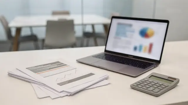 KfW-Kredit für die Gründung: Förderunterlagen und Laptop auf einem Startup-Schreibtisch