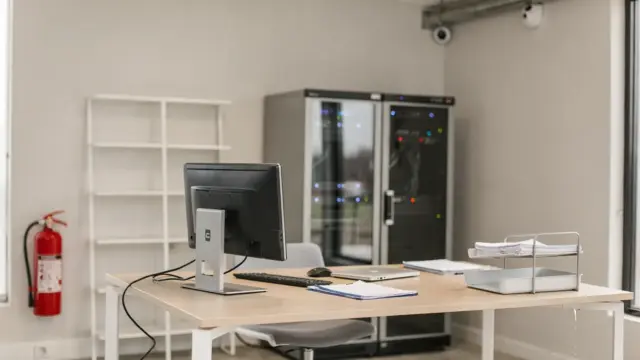 Büro mit Feuerlöscher, Wasserschutz und Technik für Sachversicherung für Unternehmen