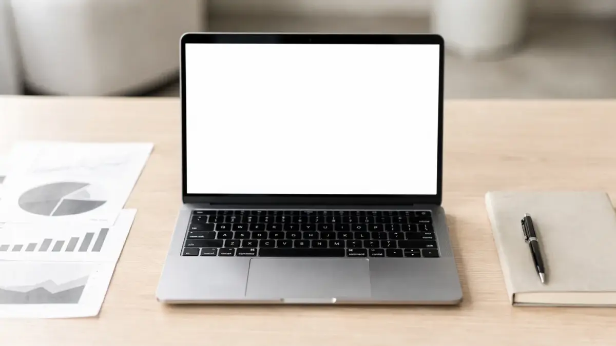 SEO-Texte schreiben: Laptop, Notizbuch und Diagramme auf einem Schreibtisch im Büro