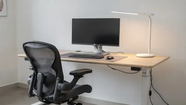 Ergonomisch eingerichteter Homeoffice-Arbeitsplatz mit höhenverstellbarem Schreibtisch, Monitor und Bürostuhl